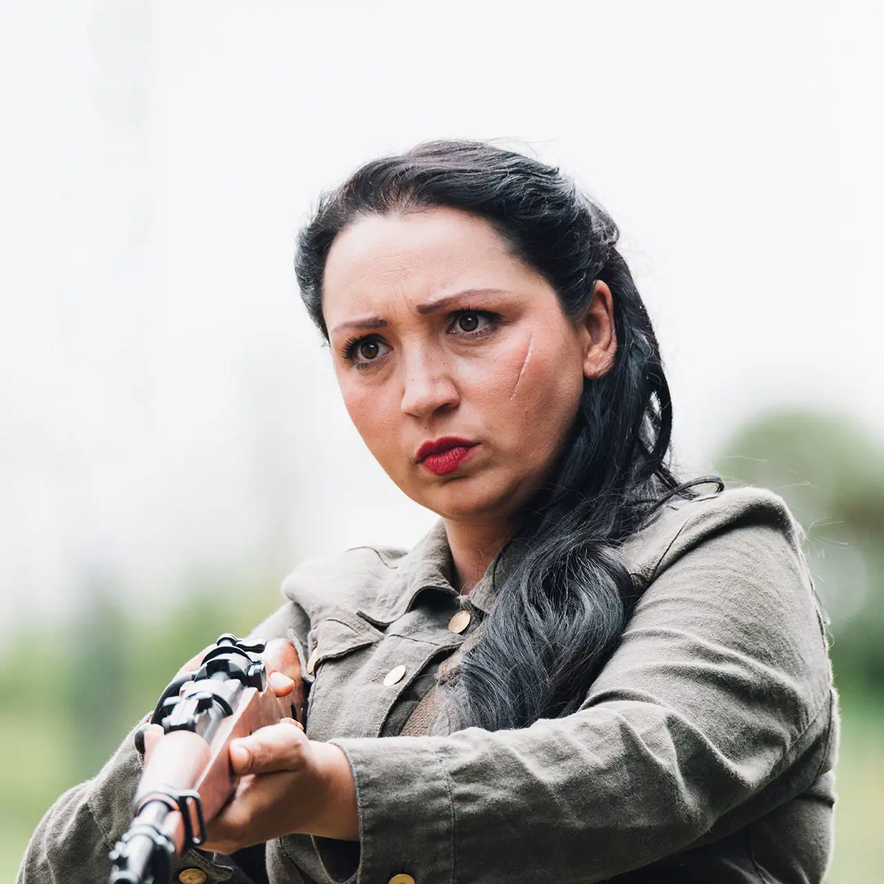 actor Katarina Kokenyova aiming a rifle